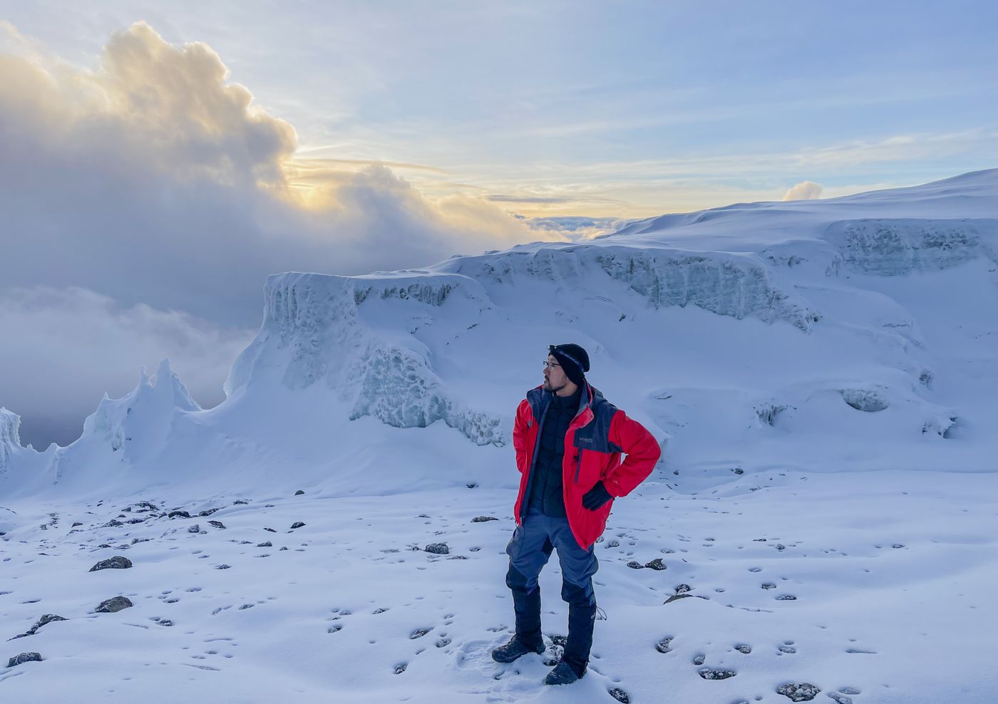 Climber at snowy summit of Kilimanjaro at sunrise