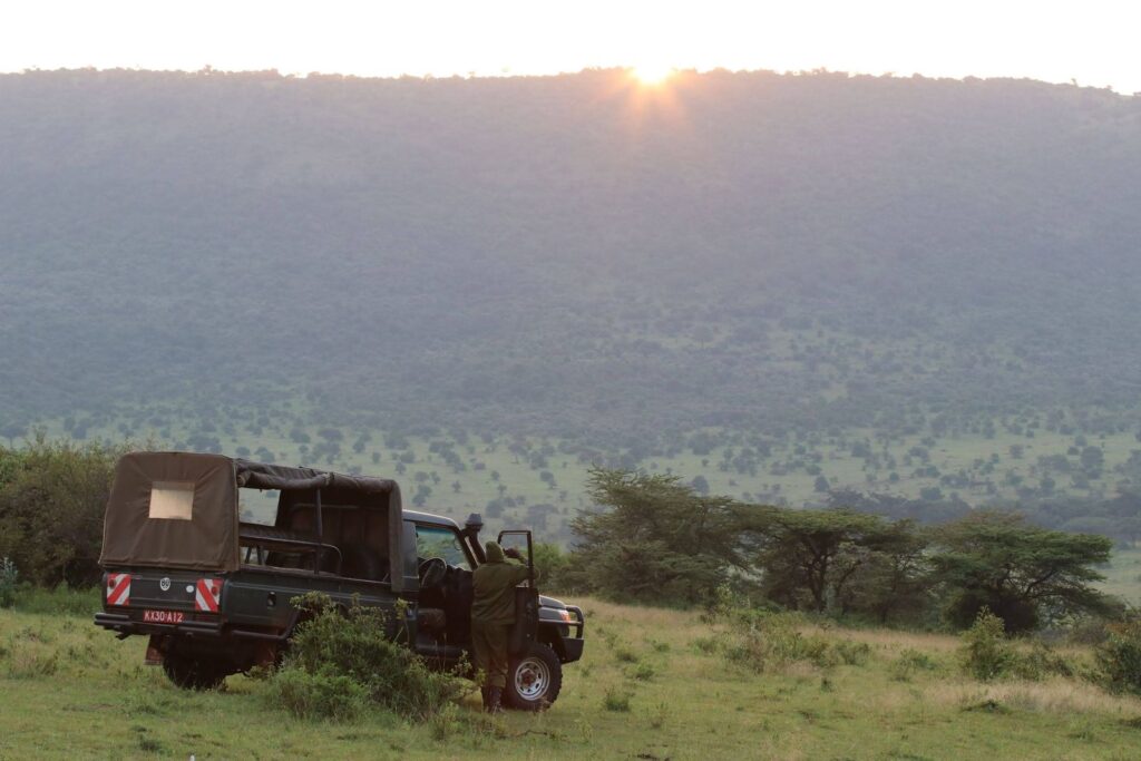 Pop-top Viewing 4x4 2 Safari viewing vehicle parked on scenic savanna at sunset
