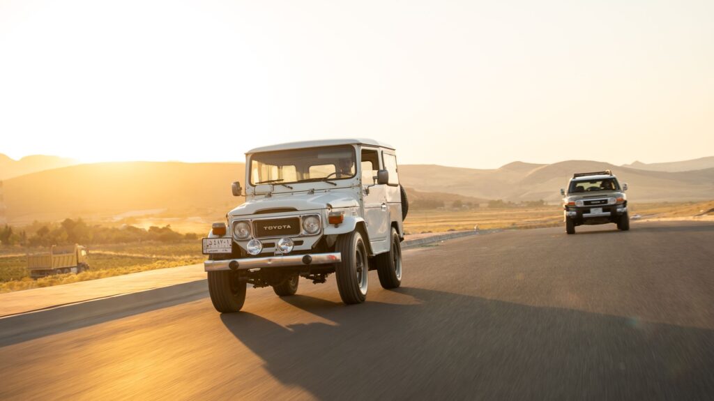Toyota Land Cruiser on an open road at sunset during a Kenya safari transfer